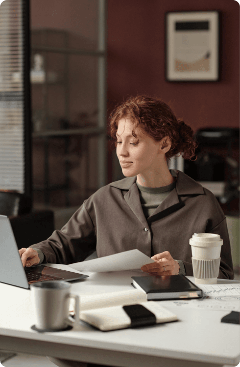 Recruiter reviewing documents at a laptop in a modern office